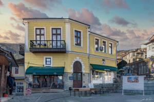 un edificio giallo con una panchina davanti di Boutique Hotel St Nikolas by Skar a Kruševo