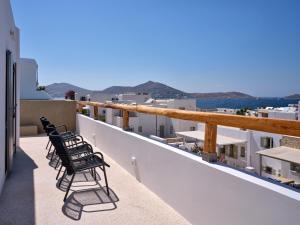 a row of chairs sitting on the balcony of a building at Siora of Paros - Ammiralis & Castelis in Naousa