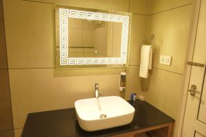 a bathroom with a sink and a mirror at Hotel Bekal International in Kāsaragod +43 photos