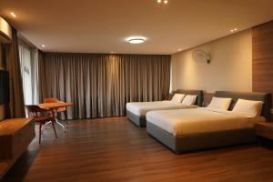 ein Hotelzimmer mit 2 Betten und einem Tisch in der Unterkunft Hotel Bekal International in Kasaragod