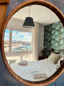 een slaapkamer met een bed en een groot raam bij El Atardecer Skyline romantic views in Málaga