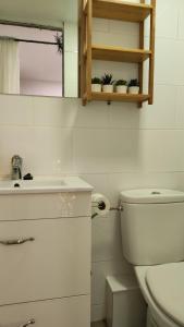 a white bathroom with a toilet and a sink at Estudio DuplexBCN in Barcelona