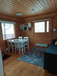 ein Wohnzimmer mit einem Tisch und Stühlen in einer Hütte in der Unterkunft Apteekkarinmökki in Forssa