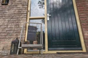 a window with a sign in front of a door at De Zingende Wilg, heerlijk huisje met Hottub in Ewijk