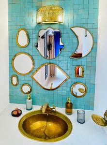 baño con lavabo y espejos en la pared en Qasabah Majorelle, en Saint-Gilles-les-Bains