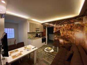 Il comprend un salon et une cuisine avec un canapé et une table. dans l'établissement Skenderija-Cityscape apartments, à Sarajevo