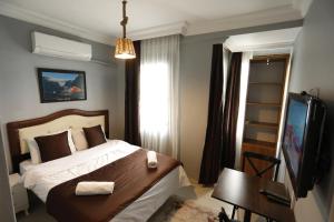 イスタンブールにあるHotel 61 istanbulのベッドルーム(ベッド1台、デスク、テレビ付)