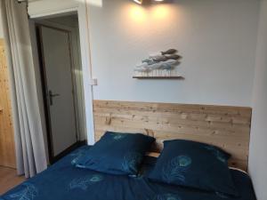 a bedroom with a bed with blue sheets and pillows at Douceurs du littoral in Calais