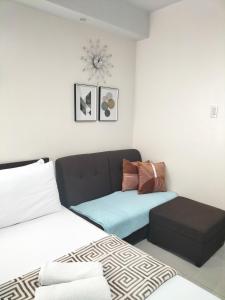 ein Wohnzimmer mit einem Bett und einem Sofa in der Unterkunft Cozy235 studio at The Persimmon in Cebu City