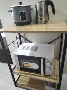 a microwave and a toaster on a shelf at Cozy235 studio at The Persimmon in Cebu City