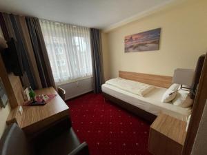 ein Hotelzimmer mit einem Bett und einem Fenster in der Unterkunft Hotel Harburger Hof in Hamburg