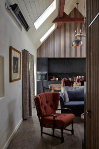 een woonkamer met een rode stoel en een bank bij Monkstadt No 10 The Horse Walk in Totscore