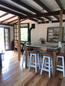 una cocina con una gran mesa de madera y taburetes en Cabaña La Colmena en Tigre