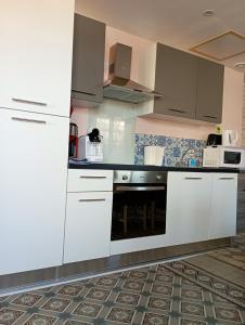 una cucina con armadietti bianchi e piano cottura di Maison de 2 chambres avec jardin clos et wifi a Saint Blimont a Saint-Blimont