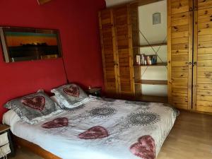sypialnia z łóżkiem i czerwoną ścianą w obiekcie Maison de vacances Biscarrosse Lac w mieście Biscarrosse