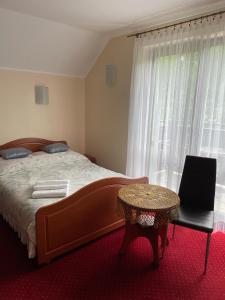 a bedroom with a bed and a table and a window at Willa pod Gruszą in Ustroń +28 photos