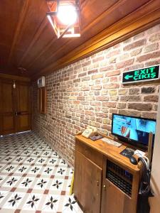 a room with a brick wall and a desk with a television at Authentic Turkish Home Family Room in Istanbul