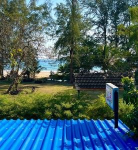 a blue water fountain in a park with a bench at Twocans Resort KohMak - SHA in Ko Mak
