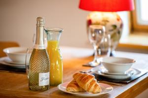 a table with a bottle of orange juice and croissants at Luxury Studio Suite in Stamford Centre - The Old Seed Mill - A in Stamford