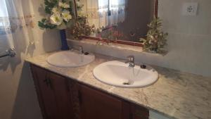 a bathroom with two sinks and a mirror at CASAS CUEVAS ELVIRA in Hinojares