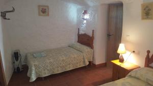 Dormitorio pequeño con 2 camas y lámpara en CASAS CUEVAS ELVIRA, en Hinojares
