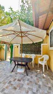 a table and chairs under an umbrella on a patio at Case Barone di Muro in Torre dell'Orso