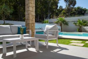 een patio met een bank, een tafel en een zwembad bij Villa Perla del Mare in Alcamo Marina