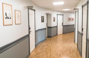 a hallway with doors and paintings on the walls at Cochs Pensjonat in Oslo