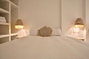 a bedroom with a white bed with two lights at KOKOON in Parikia