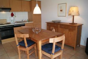 cocina con mesa de madera y 2 sillas en Ferienwohnung 105 Haus Katharina mit Balkon, en Lauterbach
