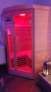 una habitación con luces rojas en la parte trasera de una máquina en ESCAPE ZEN Suite & spa privatif, en Chambly