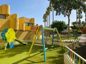 een speeltuin met een glijbaan in een park bij Blue Pearl in La Oliva