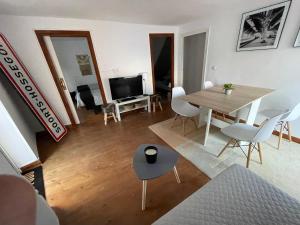 sala de estar con mesa, sillas y TV en Singular apartamento en Elantxobe Urdaibai en Elanchove