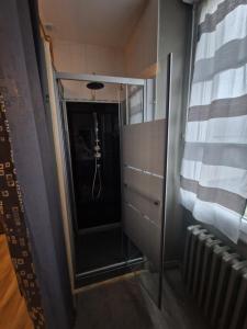 a hallway with a glass door leading to a bathroom at Hotel Saint François Précigné Soirée étape sur demande Proche Sablé-sur-Sarthe in Précigné