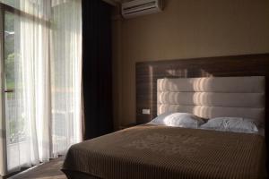 a bedroom with a bed and a large window at Palma Hotel in Gagra