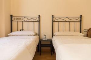 dwa łóżka ustawione obok siebie w pokoju w obiekcie Candié by Gades Gestión w Kadyksie