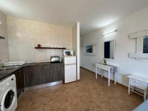 a kitchen with a white refrigerator and a microwave at Estudi Es Carnatge in Playa Migjorn