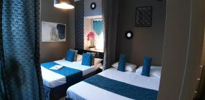 2 camas en una habitación de color azul y blanco en Hotel Saint François Précigné Soirée étape sur demande Proche Sablé-sur-Sarthe en Précigné