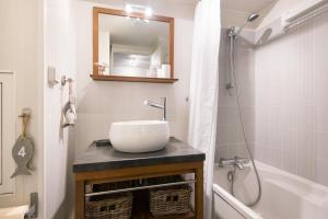 a bathroom with a sink and a shower and a tub at Les Mouettes Appartement cosy avec piscine in Saint-Martin-de-Ré +6 photos