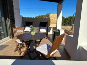 un patio con tavolo e sedie sul balcone. di Estudi Es Carnatge a Playa Migjorn