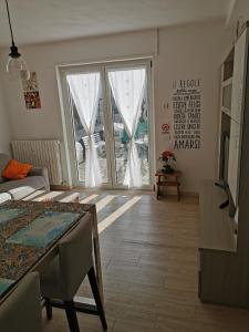 een woonkamer met een tafel en een groot raam bij Residenza Le Torri in Tirano