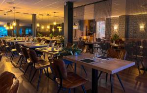 une salle à manger avec des tables et des chaises dans un restaurant dans l'établissement Auberge Les Tilleuls, à Saint-Jorioz