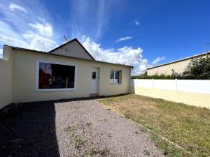 Biały dom z oknem i płotem w obiekcie Auva - SILS Maison 48 m2 à 5 minutes à pied de la plage w mieście Saint-Aubin-sur-Mer