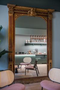 フローニンゲンにあるHotel Halbertの椅子とテーブル付きの部屋の鏡