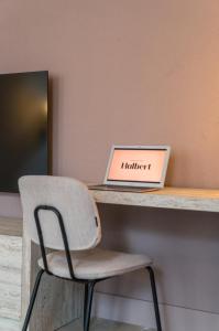 a chair sitting in front of a desk with a laptop at Hotel Halbert in Groningen