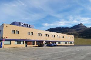 un hotel con dos coches estacionados en un estacionamiento en Andamur San Román, en San Román