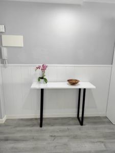 a white table with a vase of flowers on it at NAUTILUS in Torrevieja