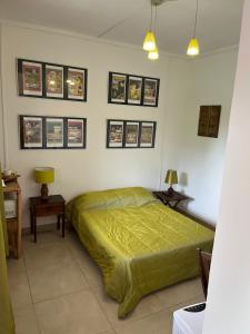 ein Schlafzimmer mit einem Bett und einige Bilder an der Wand in der Unterkunft Le Tuléar - Aux 4 coins du monde in Saint-Pierre