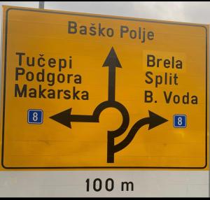 un letrero de calle amarillo con flechas apuntando en diferentes direcciones en OAZA MIRA Mobile Houses - Camp Baško Polje #BestOffer en Baška Voda