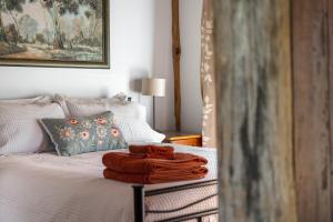 a bed with a pile of towels on it at Gaddleen Grove Cottages in Wodonga